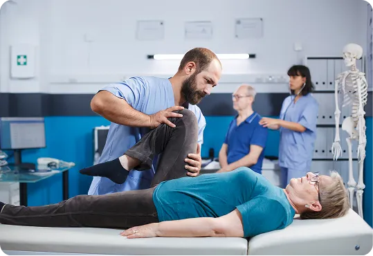 depicts a rehabilitation session, specifically kinesiotherapy or physiotherapy.