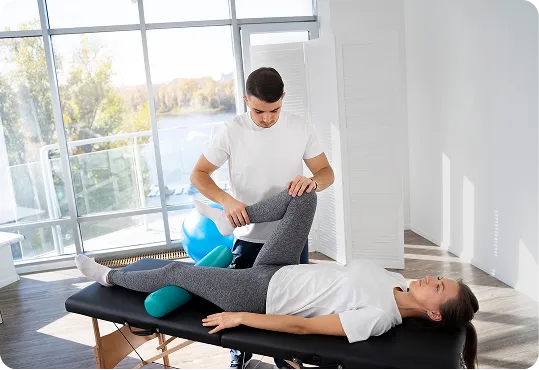 A healthcare professional performing physiotherapy on a patient in a clinic.