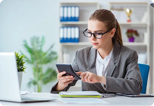 shows a person using a calculator in an office setting